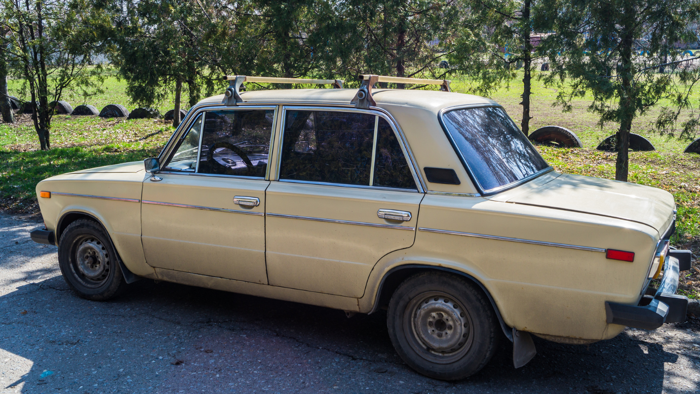 An old car with a surfboard on top of it